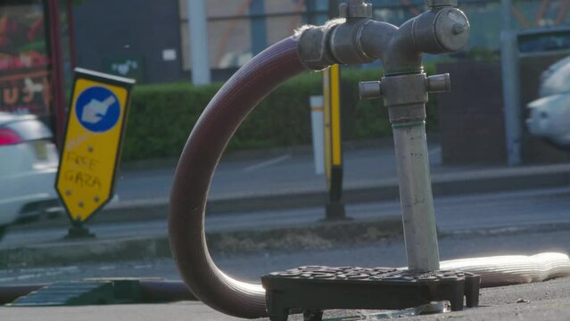 A well in a street has been opened and a fire hydrant connection point to supply water on road in england uk.