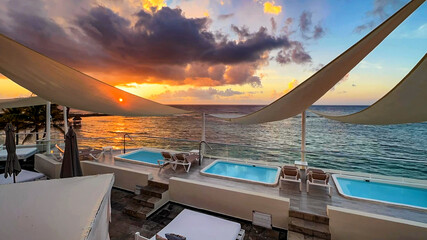 Incredible sunset from a balcony of a luxury resort in the Caribbean, with a background of crystal...