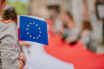 Flaga Polski  i Unii trzymana w dłoni