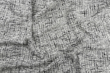 Texture of draped white and black tweed woven fabric textile background, Chanel style classic fabric, top view.