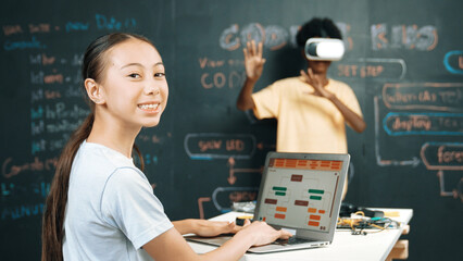 African boy using VR glasses while young woman looking at camera and coding or programing system....