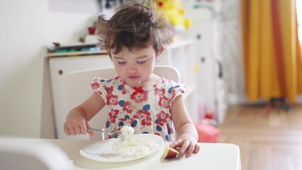 the girl eats at the table. happy family child dream concept. girl sits indoors at a white table...