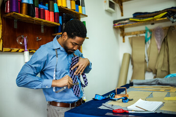 African American men fashion designer, tailor making a tie.