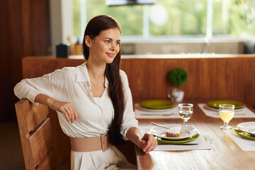 Elegant Dinner Date at Home Smiling brunette woman enjoying a romantic evening at a stylishly set...