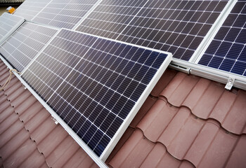 Close up view of solar photovoltaic panel system on house roof.