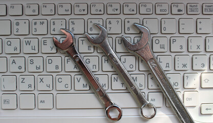 Computer Support Concept Stock Photo. Three Steel Spanners Lying On Bilingual Keyboard  
