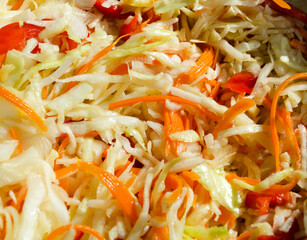 Sauerkraut with carrots and peppers in a saucepan.