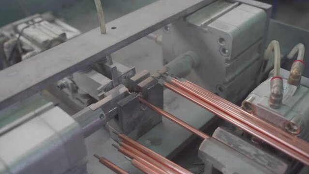 Factory production of heating element. Heating exchanger workshop. Inserting heat wire into copper tubes or pipes. Mass factory production.