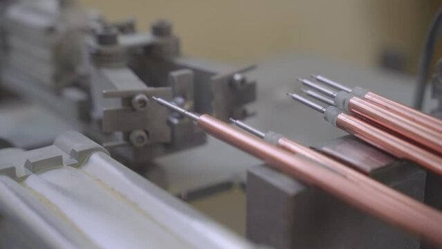 Factory production of heating element. Heating exchanger workshop. Inserting heat wire into copper tubes or pipes. Mass factory production.