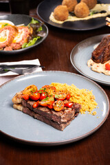 dinner banquet table in steakhouse with sirloin steak and farofa in focus
