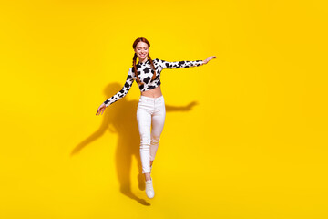 Full length portrait of pretty carefree person jumping good mood empty space isolated on yellow...