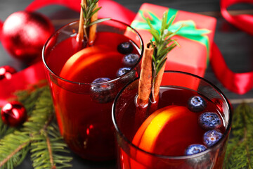 Aromatic Sangria drink in glasses, ingredients and Christmas decor on table, closeup