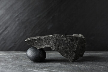 Presentation for product. Podium made of different stones on grey textured background. Space for...