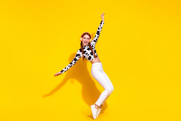 Full length profile photo of carefree cheerful person dance stand tiptoes enjoy music headphones isolated on yellow color background