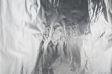 Crumpled silver foil as background, top view