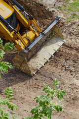 Fototapeta premium Bulldozer bucket on a dirt road, road construction, bulldozer work, close-up, vertical shot