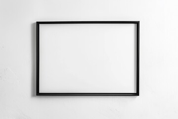 A black picture frame hangs on a white concrete wall.