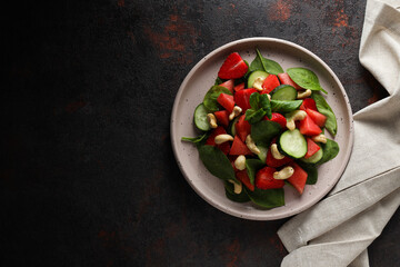 Watermelon salad in a bowl on a dark background