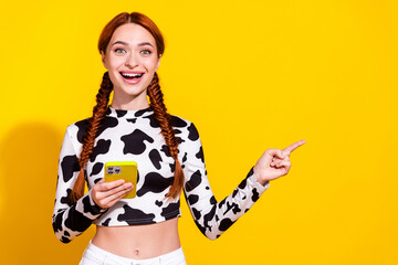 Photo of impressed funky woman wear cow skin print top texting messages gadget pointing empty space...