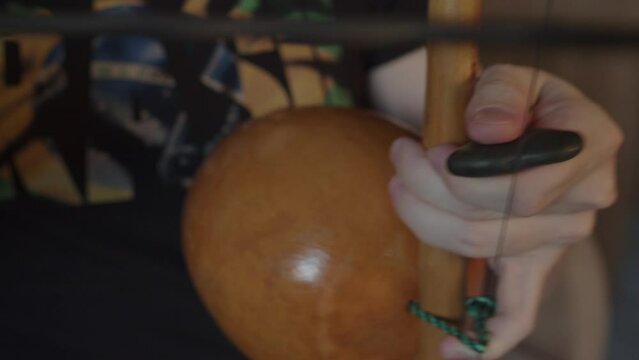 A man plays the Brazilian folk instrument, the berimbau.
