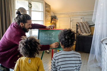Happy children learning maths with father, teacher at home. Family education happiness concept