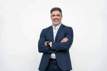 Smiling confident latin hispanic mature business man standing crossed arms isolated on white background. Older senior businessman professional ceo, coach, leader looking at camera. Banner, copy space