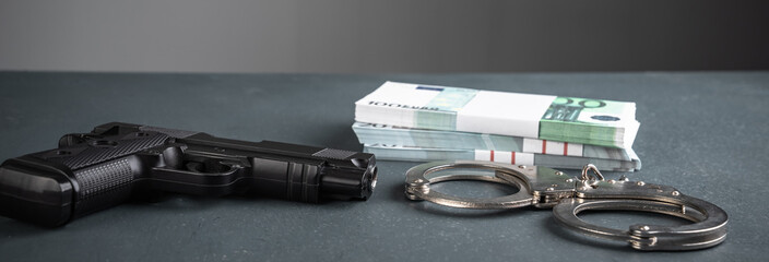 Gun, handcuffs and money on black background, stock photo, criminal concept