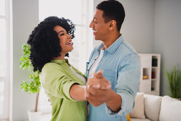 Photo of charming pretty couple dressed casual outfit enjoying dance together indoors house room