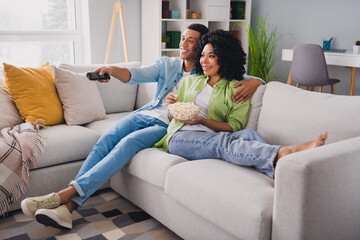 Obraz premium Full size photo of nice young man girl sit sofa hugging watch tv eat pop corn modern interior indoors cozy daylight apartment living room