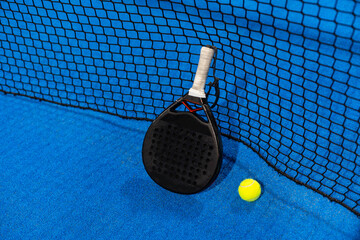 paddle tennis racket and balls on the blue paddle court