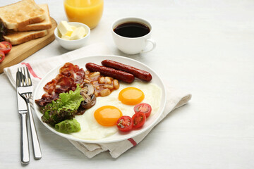 Delicious breakfast with sunny side up eggs served on white table
