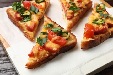Tasty pizza toasts served on wooden table, closeup