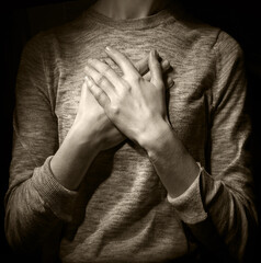 Hands folded in prayer over the heart