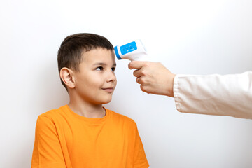 The child's body temperature is measured with a non-contact thermometer.