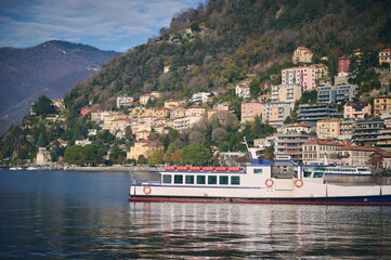 Beautiful touristic boat floating on a clean transparent water of the lake of Como in Italy,...