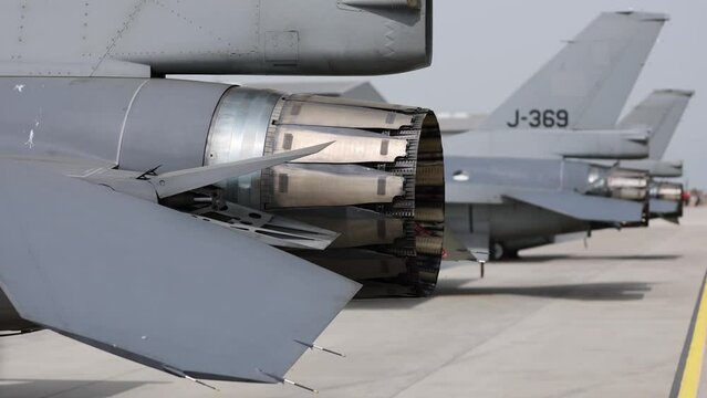 Fighter jet exhaust nozzle detail on a lot of fighter airplanes in parking position. 