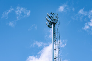 tall light pole for soccer field over blue sky and clouds