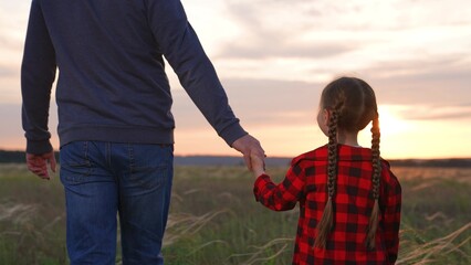 Daughter father holding hands at sunset. Little kid child baby man daddy strolling forward together...