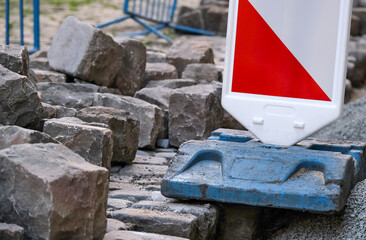 road markings around pavement work, a pile of cobblestones