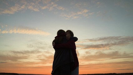 Girls friends hugging at sunset in park, silhouettes. Happy smiling girls women acquaintance...