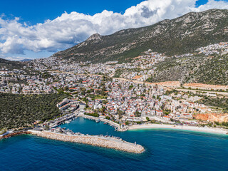 A stunning panoramic view of Kalkan, Kaş, in Antalya, Turkey, with beautiful hillside buildings and the tranquil Mediterranean Sea.