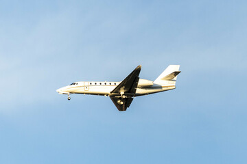 A private jet plane flying in a blue sky between clouds. Transportation. Air travel. Luxury.