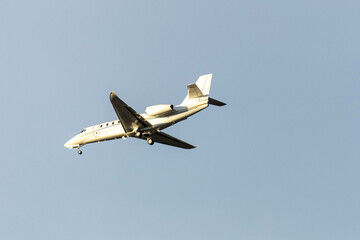 A private jet plane flying in a blue sky between clouds. Transportation. Air travel. Luxury.