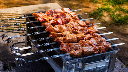 Marinated skewers are prepared on a barbecue grill over charcoal. Shish kebab or shish kebab is...
