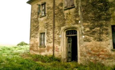 Fototapeta na wymiar Romagna house from the early 1900s, now empty for a long time, resembles a house of ghosts