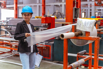 Young factory engineer woman working in metal sheet manufacturing industry 