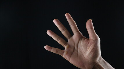 Male hand gesture number five closeup isolated on a black background