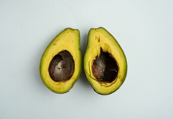 Sliced in half green unripe not ready to eat avocado fruit or vegetable object photography isolated...