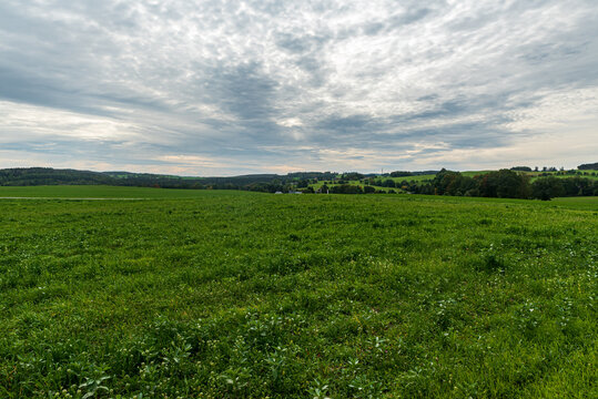 Early autumn countryside with small village and lower hills covered by meadows and forest near Plauen city in Germany