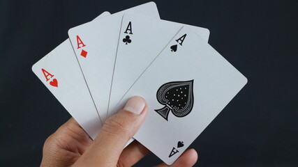hand holding four aces. Gambling addiction.